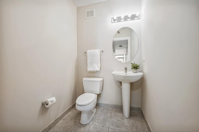 bathroom featuring baseboards, visible vents, and toilet