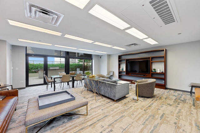 living room with light wood finished floors, baseboards, and visible vents