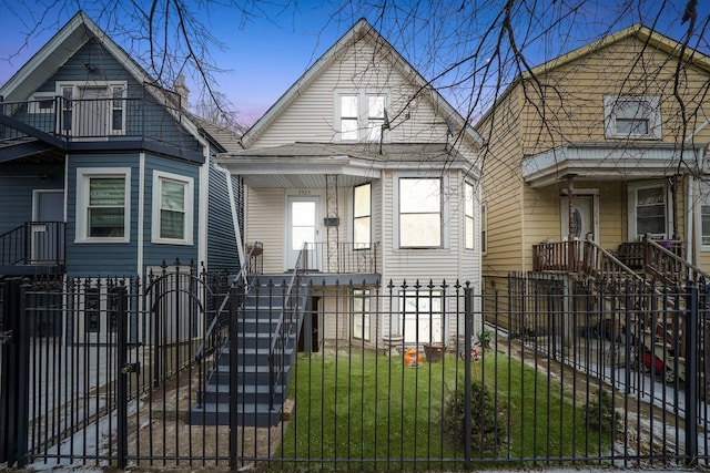 3323 N Central Park Ave, Chicago, IL 60618 - shotgun-style home with a porch, a fenced front yard, and a front lawn