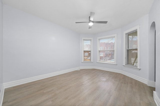 3323 N Central Park Ave, Chicago, IL 60618 - spare room with a ceiling fan, wood finished floors, baseboards, and arched walkways