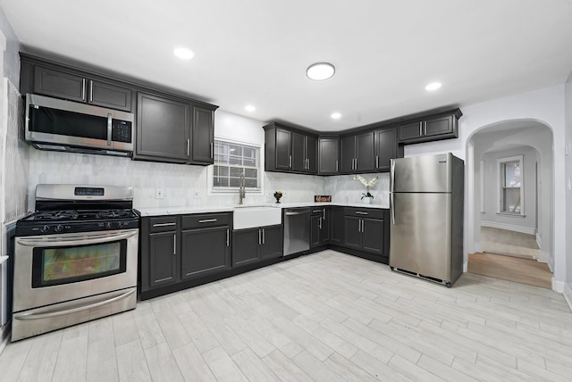 3323 N Central Park Ave, Chicago, IL 60618 - kitchen with a sink, stainless steel appliances, arched walkways, backsplash, and light countertops