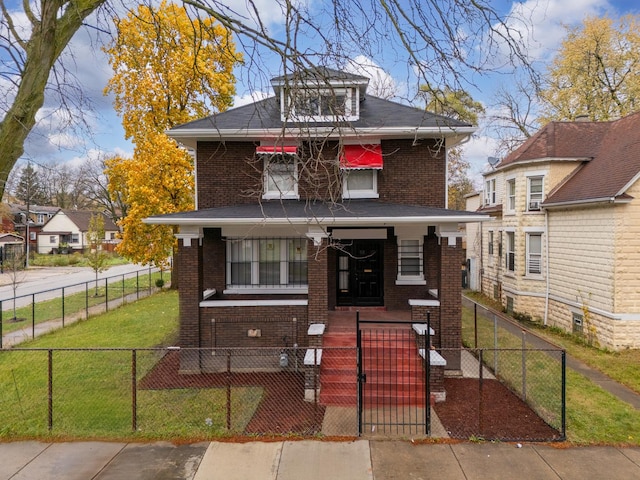 american foursquare style home with a porch, a fenced front yard, brick siding, a gate, and a front yard