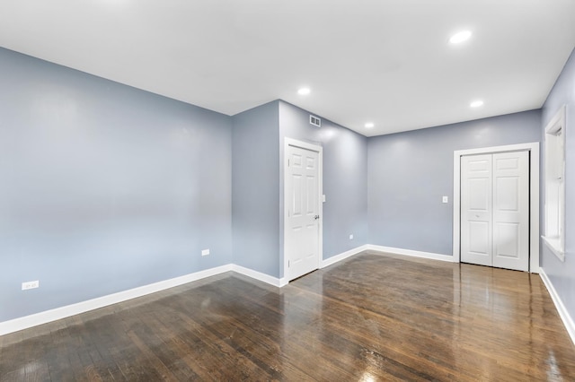 unfurnished room with dark wood-type flooring, recessed lighting, and baseboards