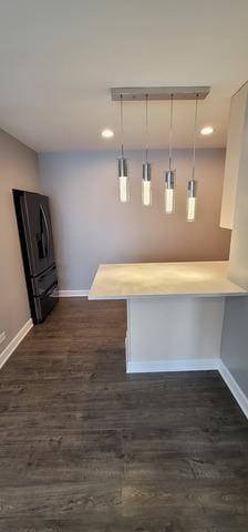 interior space with baseboards, dark wood finished floors, and freestanding refrigerator