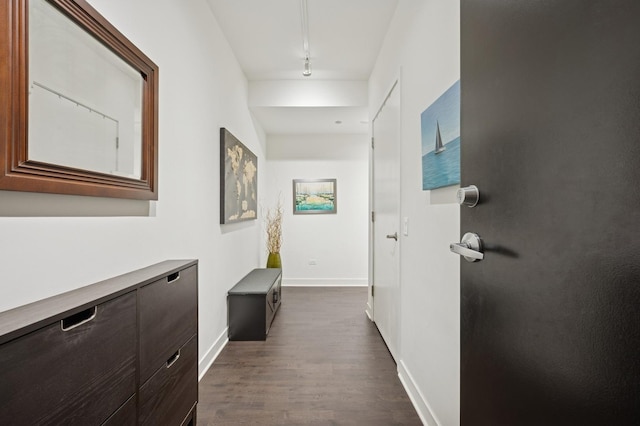 hall with dark wood-type flooring and baseboards