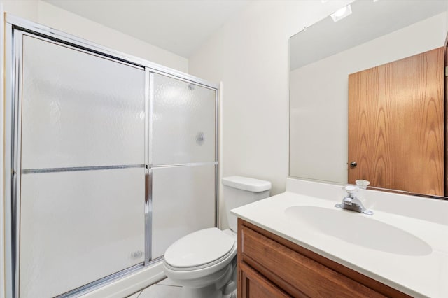 bathroom with vanity, a shower stall, and toilet