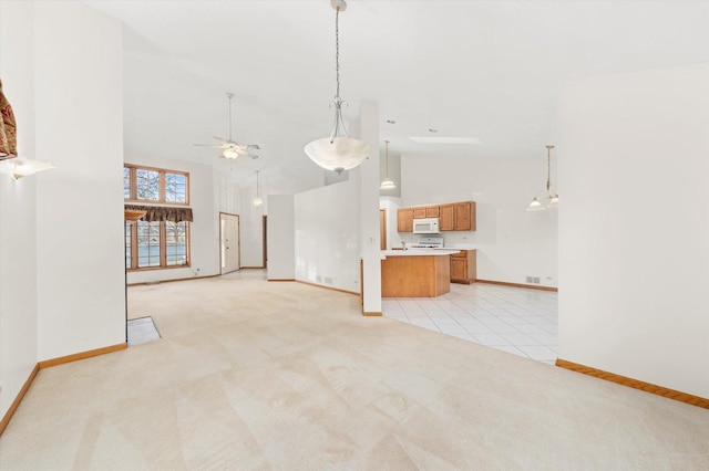 unfurnished living room featuring high vaulted ceiling, light colored carpet, baseboards, and a ceiling fan