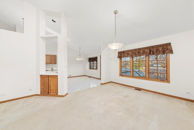 unfurnished room featuring light carpet, high vaulted ceiling, visible vents, and baseboards