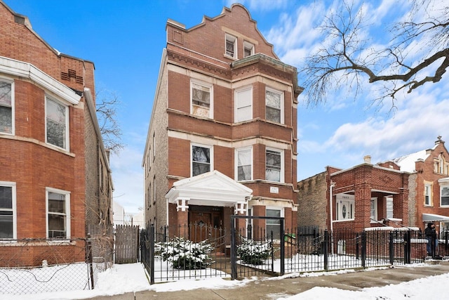 view of front facade with a fenced front yard and brick siding