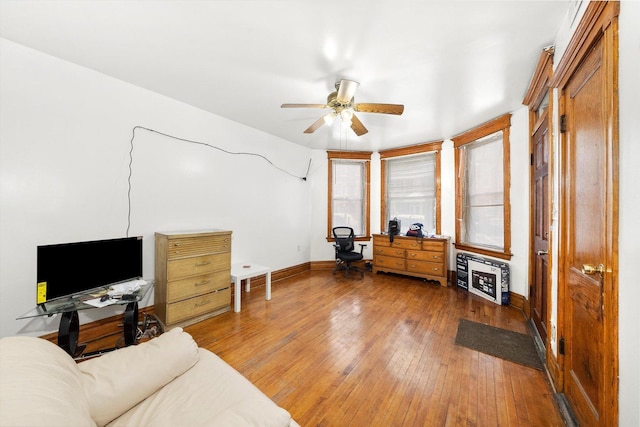 interior space featuring hardwood / wood-style floors, a ceiling fan, and baseboards