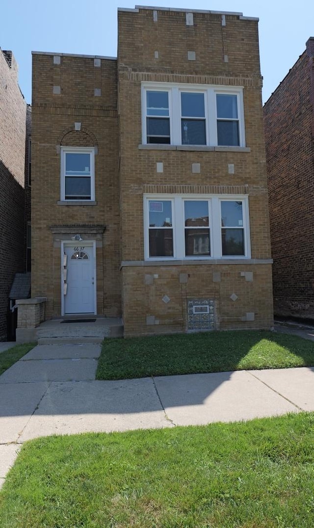 view of front of property with a front yard and brick siding