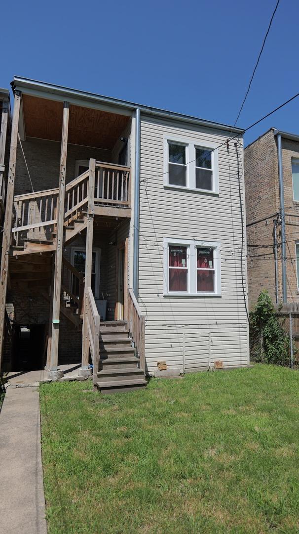 back of house with stairway and a lawn