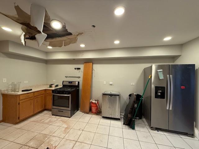 kitchen with recessed lighting, light countertops, appliances with stainless steel finishes, brown cabinetry, and light tile patterned flooring