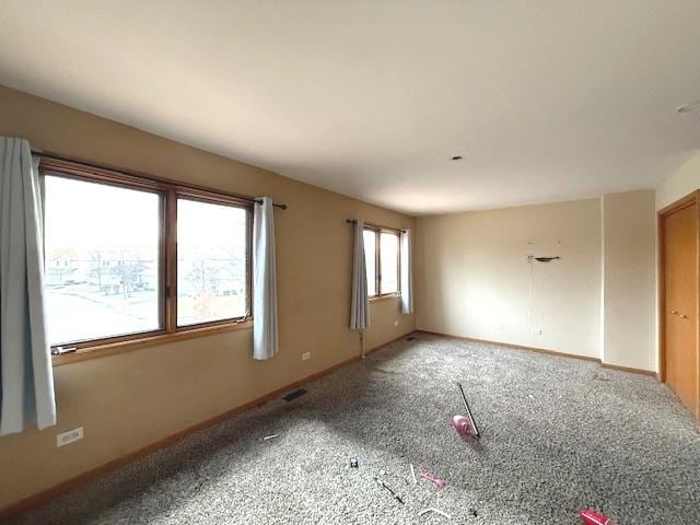 carpeted spare room featuring baseboards