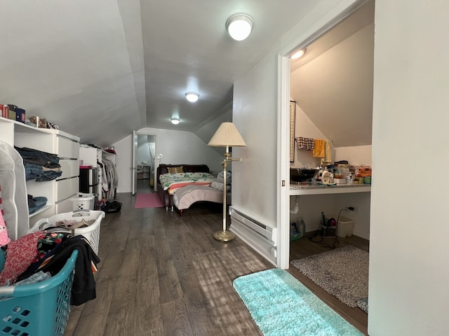 bedroom featuring a baseboard heating unit, lofted ceiling, and dark wood-type flooring