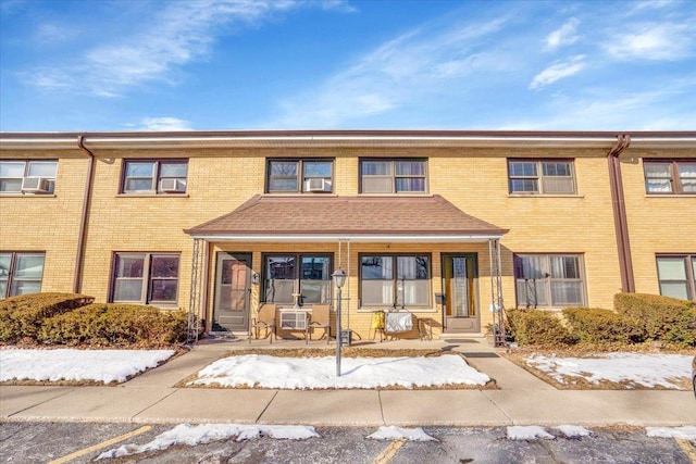 multi unit property featuring covered porch and brick siding