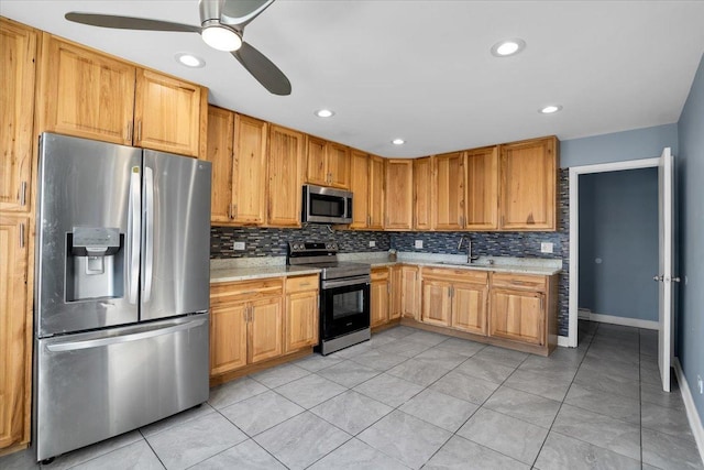 kitchen with decorative backsplash, appliances with stainless steel finishes, light countertops, and a sink