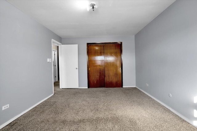 unfurnished bedroom with carpet, baseboards, and a closet