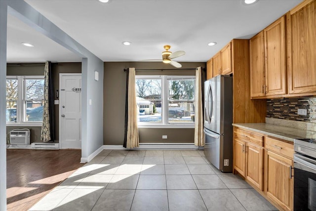 kitchen featuring light tile patterned floors, stainless steel appliances, light countertops, decorative backsplash, and baseboards