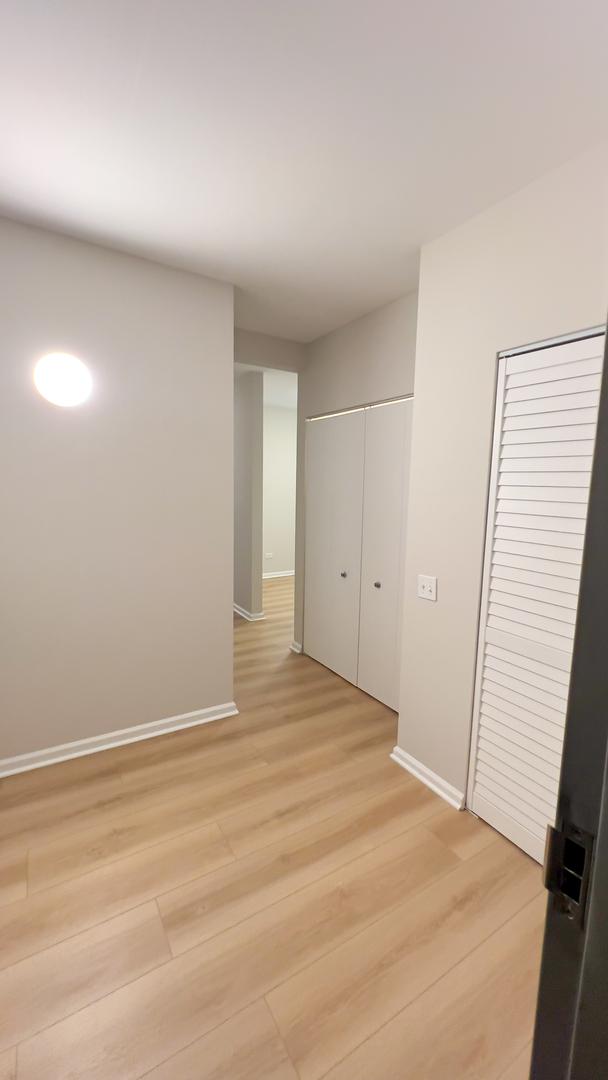 hallway with light wood finished floors and baseboards