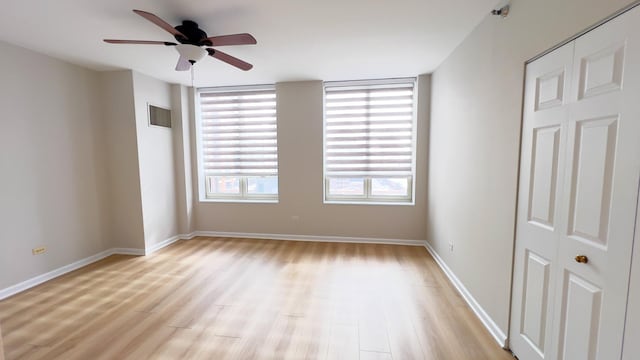 unfurnished room featuring a ceiling fan, visible vents, light wood-style flooring, and baseboards