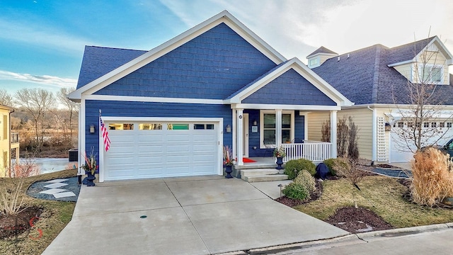 view of front of house with a garage, covered porch, concrete driveway, and roof with shingles