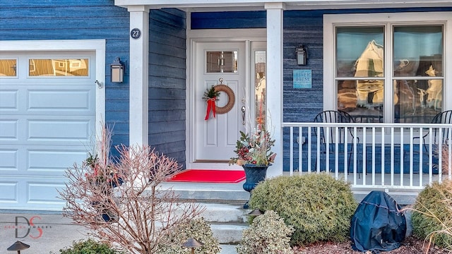 doorway to property featuring covered porch and an attached garage