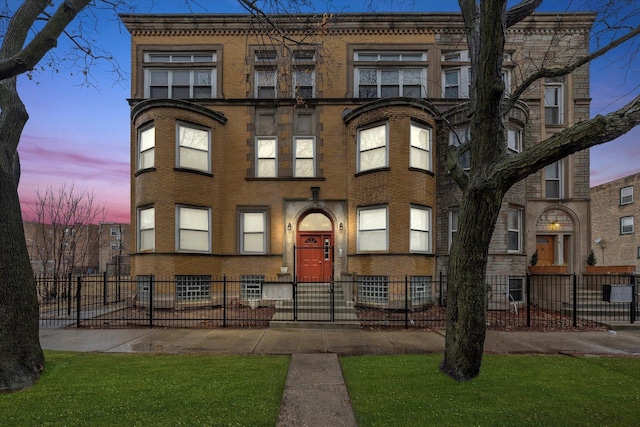 view of front facade with brick siding and a fenced front yard