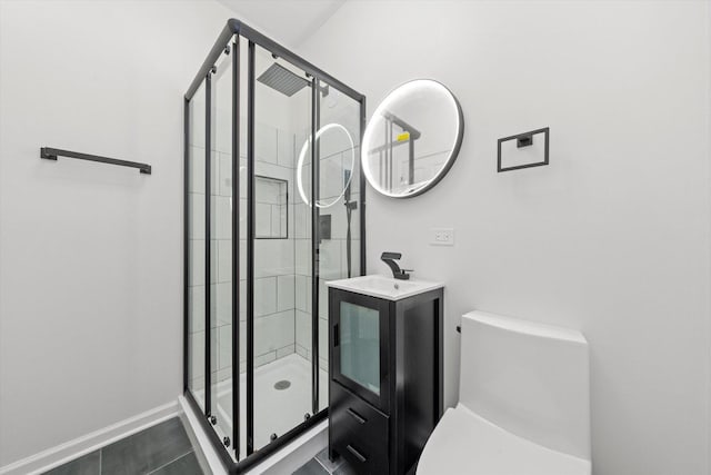 full bathroom with toilet, a shower stall, vanity, and baseboards