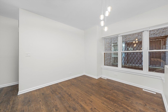 unfurnished room featuring dark wood-style floors, lofted ceiling, visible vents, and baseboards