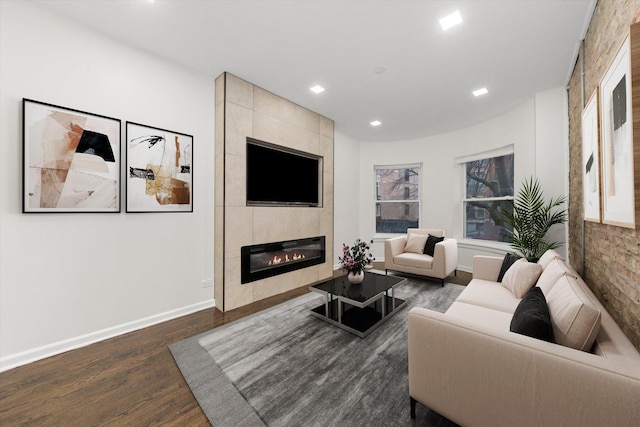 living area with recessed lighting, baseboards, dark wood finished floors, and a tiled fireplace