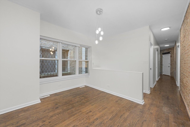 empty room featuring wood finished floors and baseboards