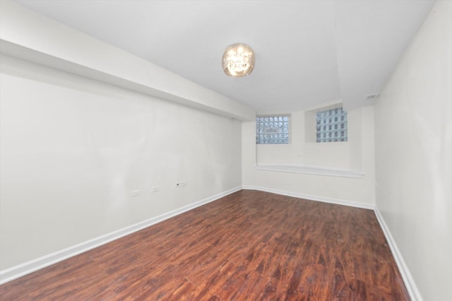 unfurnished room with baseboards and dark wood-style flooring