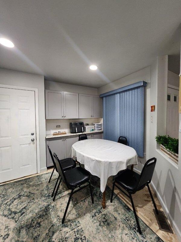 dining room featuring visible vents, baseboards, wood finished floors, and recessed lighting