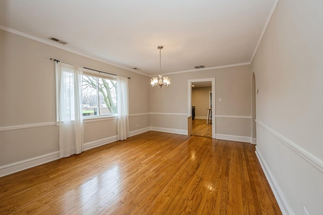 unfurnished room featuring light wood-style floors, visible vents, and ornamental molding