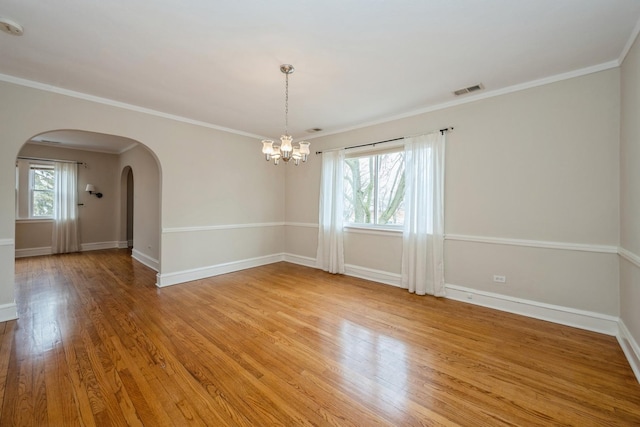 empty room featuring baseboards, visible vents, light wood finished floors, and a healthy amount of sunlight