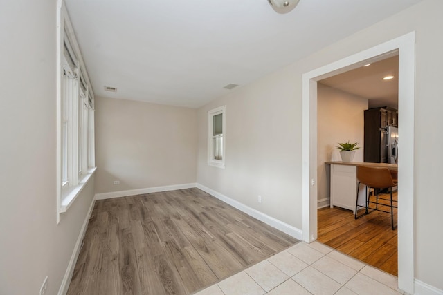 unfurnished room with visible vents, baseboards, and wood finished floors