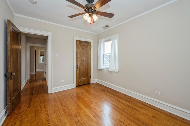 unfurnished bedroom with ornamental molding, light wood finished floors, and baseboards