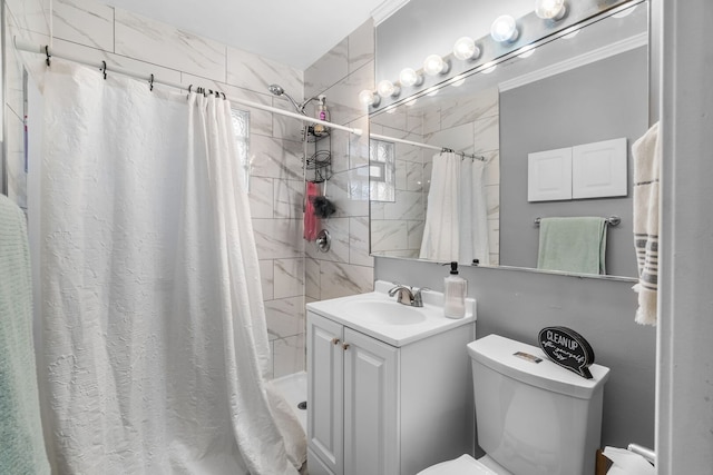 bathroom with toilet, a tile shower, crown molding, and vanity