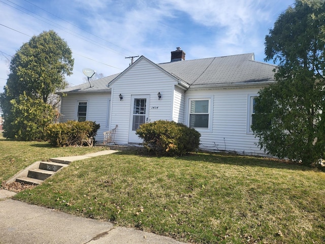 view of front facade featuring a front lawn and a chimney