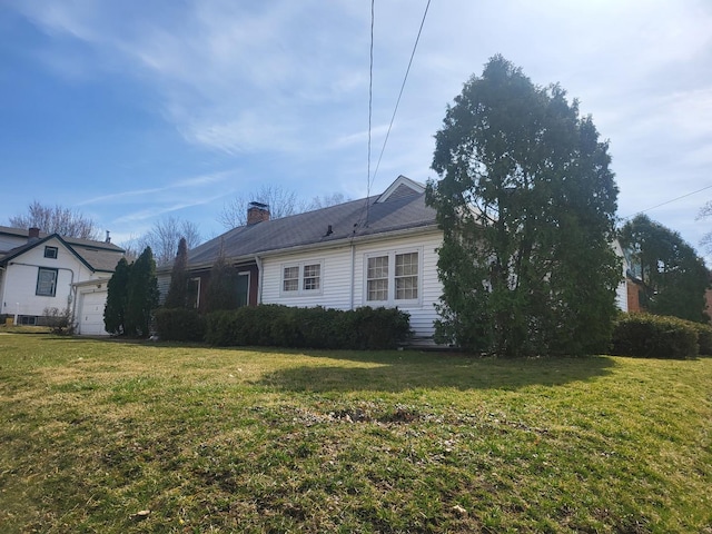 view of property exterior featuring a yard, a chimney, and an attached garage