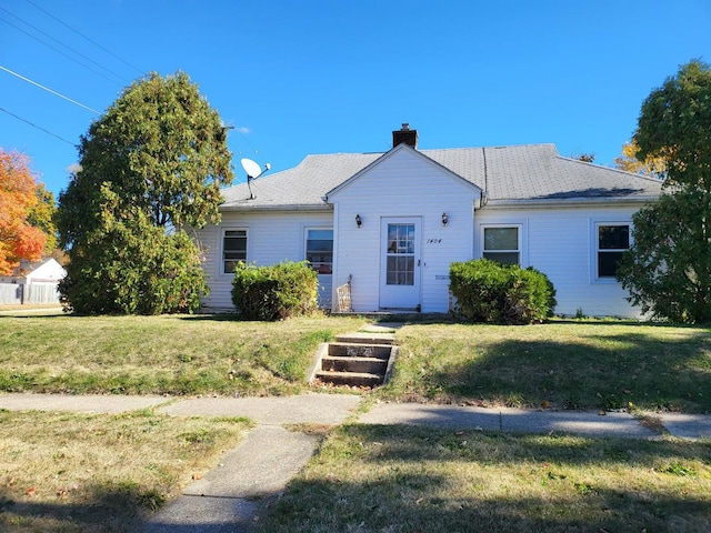 view of front of property with a front yard and a chimney