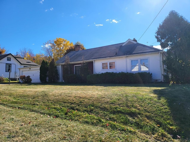 view of front facade with a garage, a chimney, and a front yard