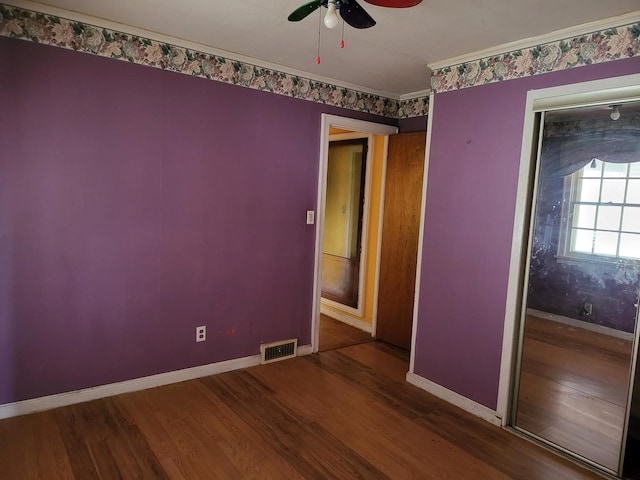 unfurnished room with a ceiling fan, baseboards, visible vents, and wood finished floors