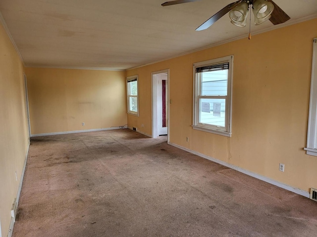 spare room with baseboards, visible vents, crown molding, and light colored carpet