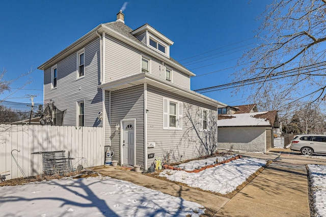 view of snowy exterior with fence