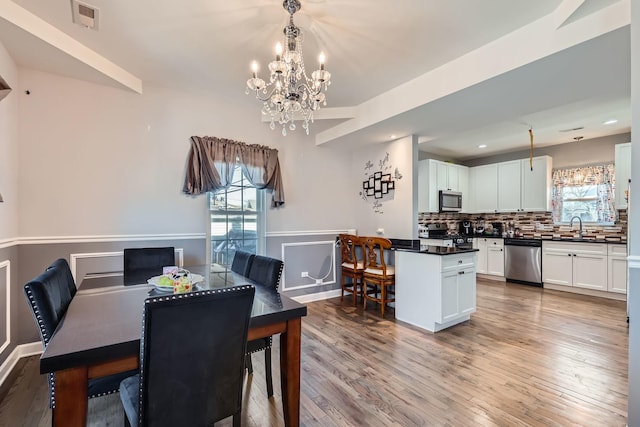 dining room with visible vents, wood finished floors, and a wealth of natural light