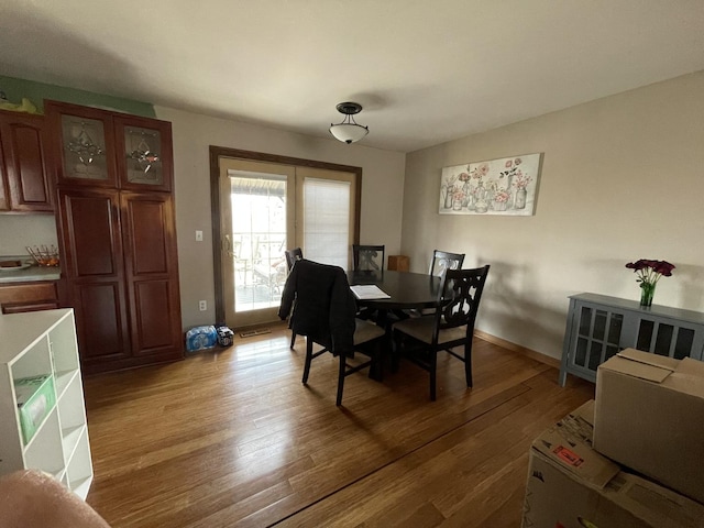 dining room featuring light wood-type flooring and baseboards