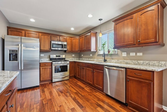 kitchen featuring recessed lighting, a sink, appliances with stainless steel finishes, dark wood-style floors, and decorative light fixtures