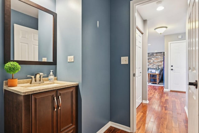 bathroom with vanity, baseboards, and wood finished floors